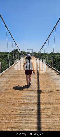 Una ragazza sta camminando sul Regency Suspension Bridge, Texas Foto Stock
