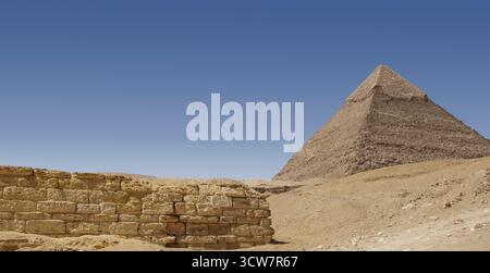 Paesaggio nel campo centrale sull'altopiano di Giza camminando tra le tombe scavate nella roccia di Kai e Khentkawes guardando verso la piramide di Khafre Foto Stock