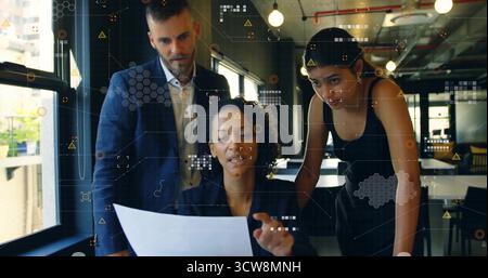 Manager in un blazer scuro che esamina il report stampato con i colleghi in open Office, con grafica dei dati. Collaborazione, lavoro di squadra, modernoffice, aziendale, Foto Stock
