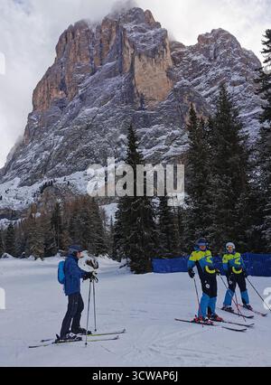 Le piste blu di Selva e Santa Cristina si estendono sotto le imponenti scogliere del Sassolungo, il Dolomiti Superski e il Sellaronda dell'alto Adige al suo meglio. Foto Stock