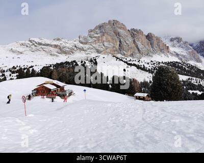 Gli sciatori scendono la pista blu del col Raiser nelle Dolomiti, con grosse Fermeda e il Rifugio Odles durante la stagione sciistica - parte della Sellaronda in Val Gardena. Foto Stock
