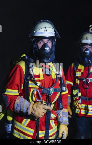 Vigile del fuoco con autorespiratore al buio, concentrato e pronto all'azione, esercitazione antincendio nel nuovo tunnel di costruzione dell'Herma Foto Stock