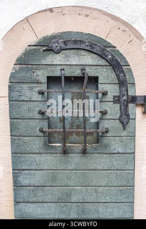 Accessori in ferro e griglie per finestre su una vecchia porta in legno, Hesse, Germania Foto Stock