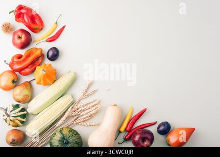 Frutta e verdura diverse su sfondo verde chiaro. Zucche, mais, peperoni, pomodori, pere, mele e orecchie di grano. Raccolto autunnale Foto Stock