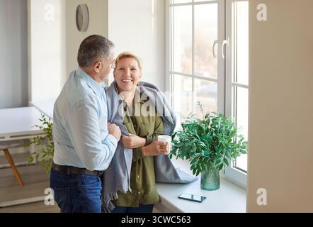 Anziani famiglia coppia abbracciare e conversare a casa Foto Stock