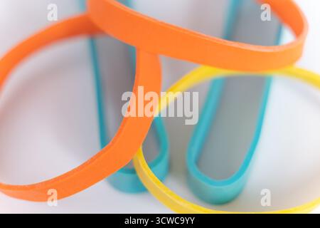 Elastici su sfondo bianco. Molti elastici in plastica colorati. Vista ravvicinata Foto Stock