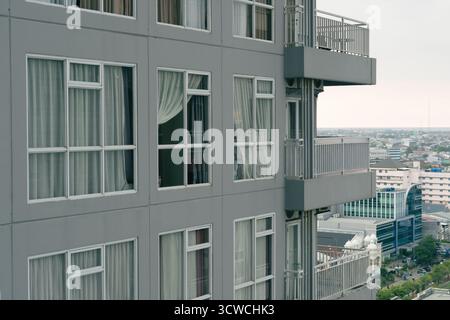 Moderno edificio di appartamenti grigio con finestre multiple e vista sulla città Foto Stock
