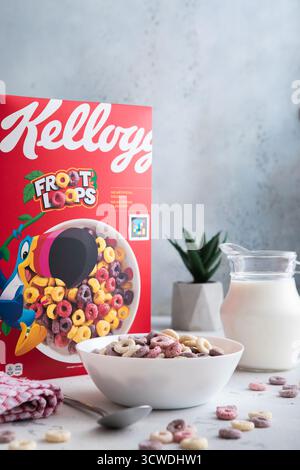 LONDRA, Regno Unito - 5 GIUGNO 2025: Colazione Froot Loops, cereali colorati in ciotola con cucchiaio e vasetto del latte sul tavolo della cucina. Foto Stock