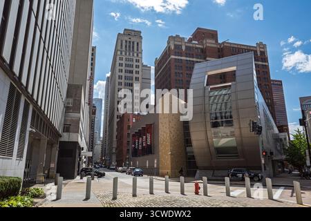 Un mix di sorprendente architettura moderna ed edifici classici in mattoni e pietra che fiancheggiano una strada nel centro di Pittsburgh, Pennsylvania. Foto Stock