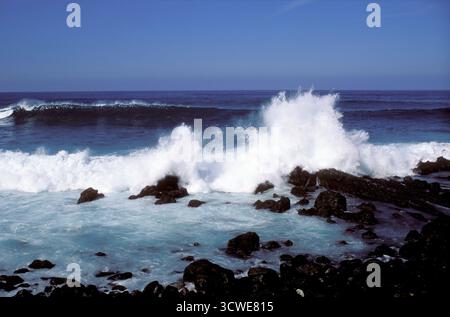 Le grandi onde che colpiscono le rocce sulla spiaggia. Sole luminoso lungo la costa atlantica. Foto Stock