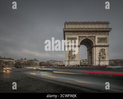 Scena serale all'Arco di Trionfo di Parigi, Francia, con sentieri leggeri del traffico intorno al monumento. Foto Stock