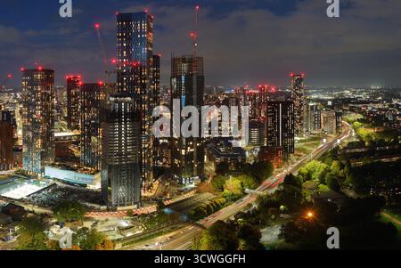 Immagine aerea al crepuscolo dello skyline di Manchester con grattacieli illuminati e la via mancuniana sottostante. Foto Stock