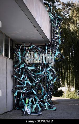 Ausstellung Â die Moeglichkeit der UnvernunftÂ , Jan Boehmermann DEU, Deutschland, Germania, Berlino, 02.10.2025 installazione e-Scooter mit - dem demokratischen Verkehrsmittel Zitat Böhmermann als sog. Scooternest , aufgestapelte Roller sollen ihre pseudo-natürliche Aufzucht humoristisch veranschaulichen, direkt neben einer Jelbi-Station im Rahmen der Ausstellung Â die Moeglichkeit der UnvernunftÂ vor dem Haus der Kulturen der Welt HKDW Kongresshalle a Berlino Germania . Jan Boehmermann , deutscher Fernsehmoderator und Satiriker ,und die Gruppe Royale vom ZDF Magazin Royale besetzen vom 2 Foto Stock