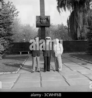 Il celebre capitano rompighiaccio sovietico Anatoly Lamekhov (centro), eroe dell'Unione Sovietica, posa per una fotografia formale con due funzionari locali nella sua città natale di Sloviansk negli anni '1980 Vestito con la sua uniforme da parata completa, l'esploratore artico decorato si erge davanti al monumento all'eroe della guerra civile Mikhail Karnaukhov. Questa immagine in bianco e nero cattura un momento di tributo ufficiale e orgoglio della comunità, un evento tipico per un eroe in visita nella RSS Ucraina Foto Stock