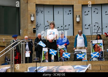 Glasgow, Scozia, Regno Unito. 12 ottobre 2025. I sostenitori dell'ex primo ministro Alex Salmond si sono riuniti a Glasgow per celebrare il primo anniversario della sua morte. I partecipanti hanno reso omaggio con discorsi, fiori e momenti di riflessione in onore dell’eredità politica dell’ex leader del SNP e dell’impatto sull’indipendenza scozzese. Crediti: Jacob Hughes/Alamy Live News Foto Stock
