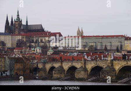 Skyline di Praga con il Ponte Carlo, il Castello di Praga e la Cattedrale di San Vito sul fiume Moldava in una giornata invernale nuvolosa Foto Stock