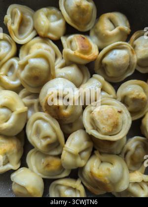 Molti gnocchi fritti in una padella, vista dall'alto. Foto Stock