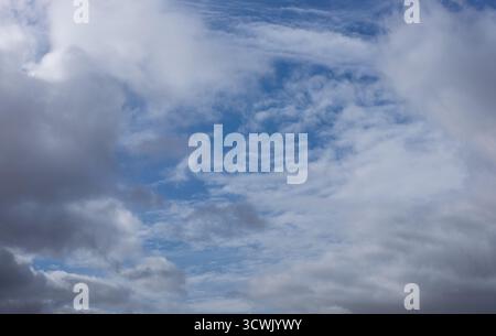 Un cielo nuvoloso con macchie di blu che sbirciano. Le nuvole si muovono, creando una scena dinamica. Adatto per la sostituzione del cielo nella modifica. Foto Stock
