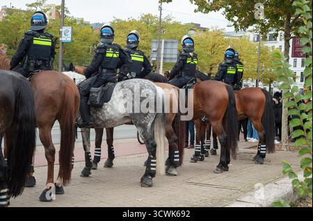 Stadhouderskade, Amsterdam, Paesi Bassi - 12 ottobre 2025: Polizia a cavallo pronta ad entrare in azione durante la protesta/manifestazione anti-immigrazione Foto Stock