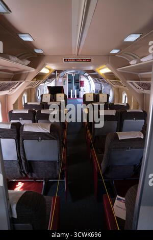 Vista interna della cabina passeggeri dell'aeromobile d'epoca con file di sedili e corridoio Foto Stock