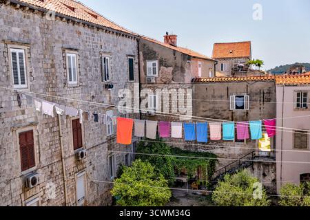 La colorata lavanderia è appesa su stretti cortili in pietra tra vecchi edifici nel centro storico della città vecchia di Dubrovnik. Foto Stock