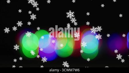 Immagine della neve che cade su macchie luminose su sfondo nero Foto Stock