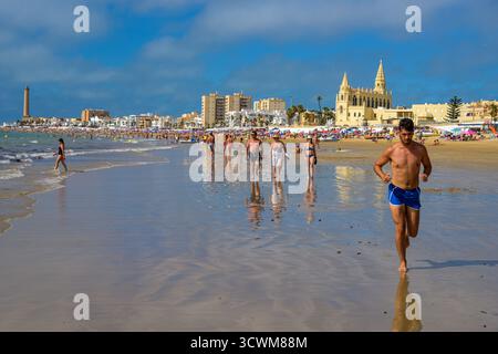 Chipiona, Spagna, 9 agosto 2019, i visitatori possono godersi una giornata di sole sulla spiaggia di Regla a Chipiona, Cadice, con gente che fa jogging e si rilassa in acqua ad agosto. Foto Stock