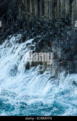 Onde oceaniche che si infrangono sul promontorio roccioso di Fingal Heads. Foto Stock