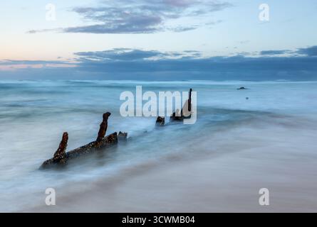 I resti arrugginiti della nave a vapore Maheno sono parzialmente sommersi nell'oceano vicino a Fraser Island, Queensland, Australia. Foto Stock