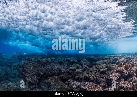 Il surf si schianta sulla barriera corallina al largo di Gun Beach sull'isola di Guam in Micronesia. Foto Stock