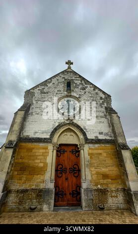 Bergnicourt, Rethel, Ardenne, Grand-Est, Francia, il 28 agosto 2025, Una vecchia cappella splendidamente realizzata, caratterizzata da un'affascinante porta in legno e un orologio ornato, adagiata su un cielo lunare Foto Stock