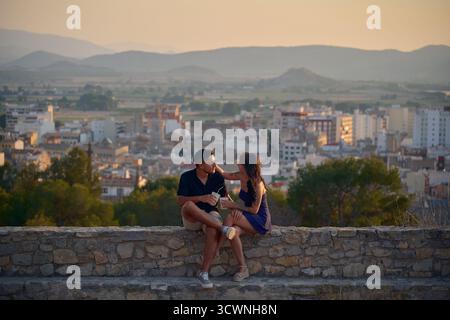 Coppia giovane che gode di una romantica vista della città al tramonto Foto Stock
