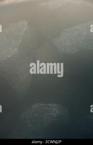 Primo piano di rocce della sauna coperte di vapore dalla sauna svedese Foto Stock