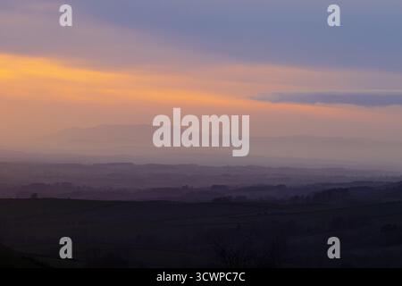 Il sole tramonta sulle montagne del Lake District e si affaccia sulla valle dell'eden. Cumbria, Inghilterra, Regno Unito. Foto Stock