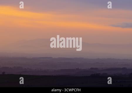 Il sole tramonta sulle montagne del Lake District e si affaccia sulla valle dell'eden. Cumbria, Inghilterra, Regno Unito. Foto Stock