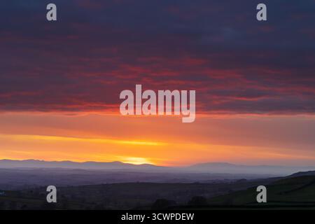 Il sole tramonta sulle montagne del Lake District e si affaccia sulla valle dell'eden. Cumbria, Inghilterra, Regno Unito. Foto Stock