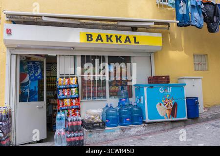 Istanbul, Turchia - 10 marzo 2023: Piccolo negozio di alimentari turco (Bakkal) con spuntini, bevande e bottiglie d'acqua sulla strada stretta. Tradizionale turco l Foto Stock