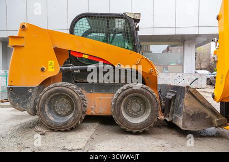 Non è un grande escavatore giallo con una benna davanti per livellare il terreno. Bulldozer gommato. Foto Stock
