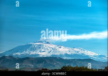 Innevato sull'Etna con fumo che si innalza in Sicilia vicino a Catania, Italia Foto Stock