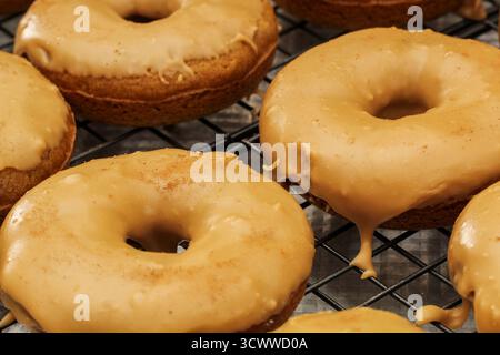 Ciambelle fresche fatte in casa con spezie di zucca su rack Foto Stock