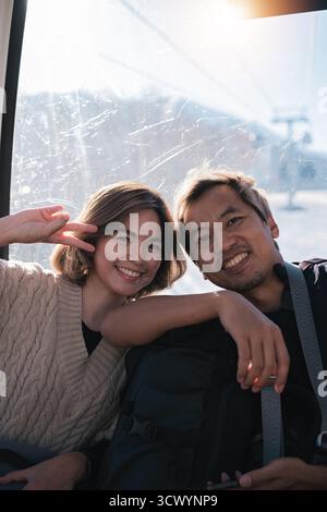 Coppia sorridente che posa all'interno della funivia. Concetto di gioia e viaggio Foto Stock