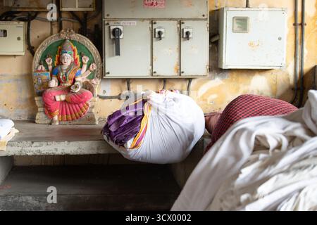 Dhobi Ghat, lavanderia all'aperto a Kochi, India, pile di vestiti puliti, lenzuola e biancheria Foto Stock