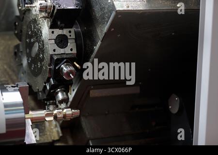 Processo di fresatura CNC su un centro di lavoro per tornio con letto inclinato e forca trilaterale. Messa a fuoco selettiva. Foto Stock