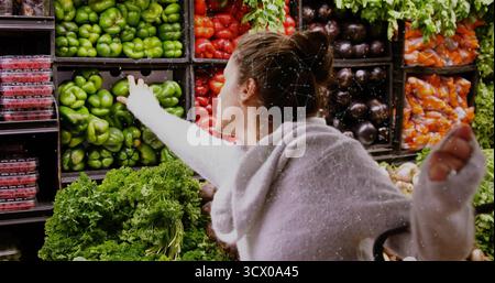 Raggiungere il cliente afferrando peperone verde alla sezione prodotti alimentari, con bacche e melanzane Foto Stock