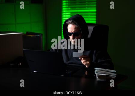 Hacking di criptovalute. Hacking alla ricerca di criptovalute. Concetto di hack di criptovaluta. Hacker in tema di notte buia con cappuccio. Sicurezza dei dati digitali Foto Stock