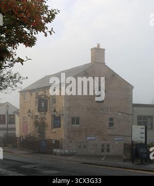 Il sole della mattina presto illumina il pub Windmill attraverso la nebbia lungo Mill Lane a Parbold. Mill Lane conduce al villaggio dalla strada principale. Foto Stock