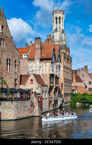 Barca turistica sul canale di Dijver da Rosary Quay, con il Befort in lontananza, nel centro storico di Bruges nelle Fiandre occidentali, Belgio, Europa Foto Stock