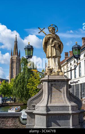 Statua di San Gioannes Nepomuceno sul ponte del Nepomuceno sul canale di Dijver nel centro storico di Bruges nelle Fiandre occidentali, Belgio, Europa Foto Stock