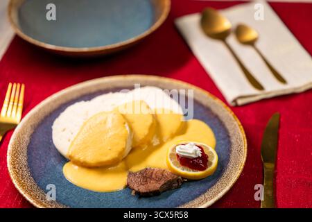 Tradizionale arrosto di manzo ceco Svickova na smetane con salsa panna, gnocchi di pane, mirtilli rossi e limone Foto Stock