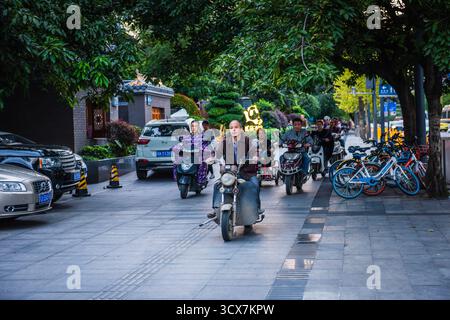 Chengdu, Cina - 28 settembre 2018: Uomini in scooter all'ora di punta nel centro di Chengdu. Foto Stock